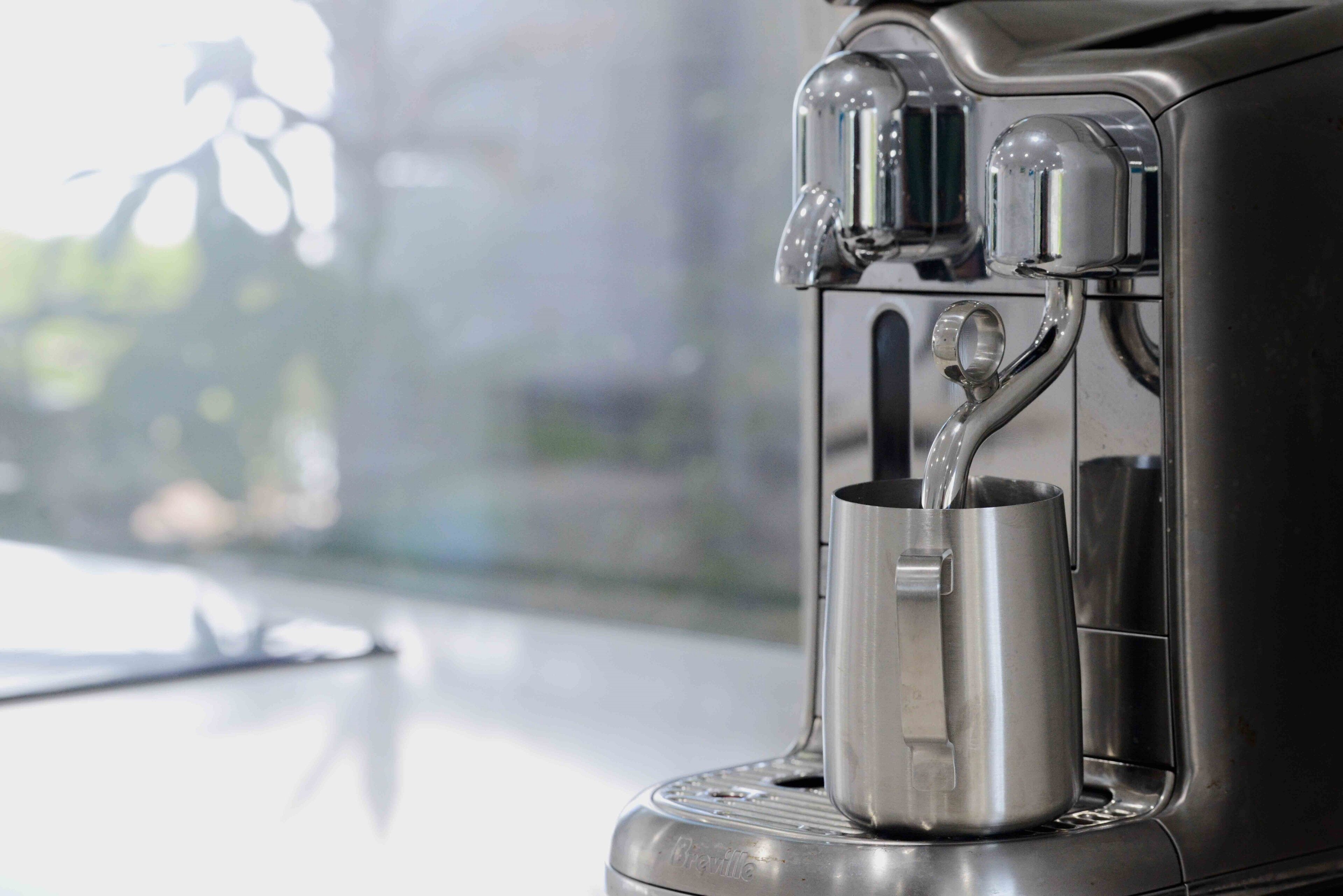 Una macchina da caffè con serbatoio dell'acqua e raccoglitore per liquidi.