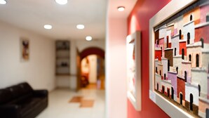 A hallway with a red wall and a framed artwork. - Mision Express Celaya (Celaya)