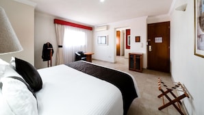 A hotel room with a bed, a chair, a desk, a wardrobe, and a door. - Mision Express Celaya (Celaya)