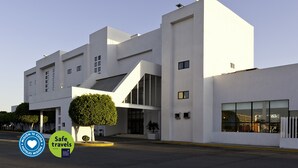 A modern hotel with a clean, white facade, large windows, and a well-maintained lawn. - Mision Express Celaya (Celaya)