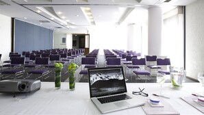 A conference room with rows of purple chairs, a projector, and a laptop on a table. - Mision Express Celaya (Celaya)