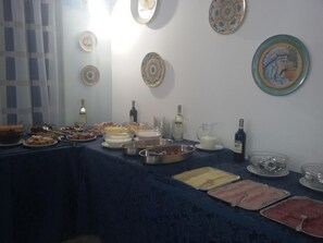 Uma mesa de buffet com diversos alimentos e bebidas.