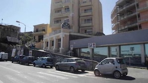 Un hôtel avec une enseigne indiquant « HÔTEL PANORAMA » et un panneau de signalisation indiquant un espace de stationnement.