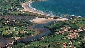 An aerial view of a coastal area with a beach, a river, and a village. - El Jardín de Carrejo (Cabezon de la Sal)