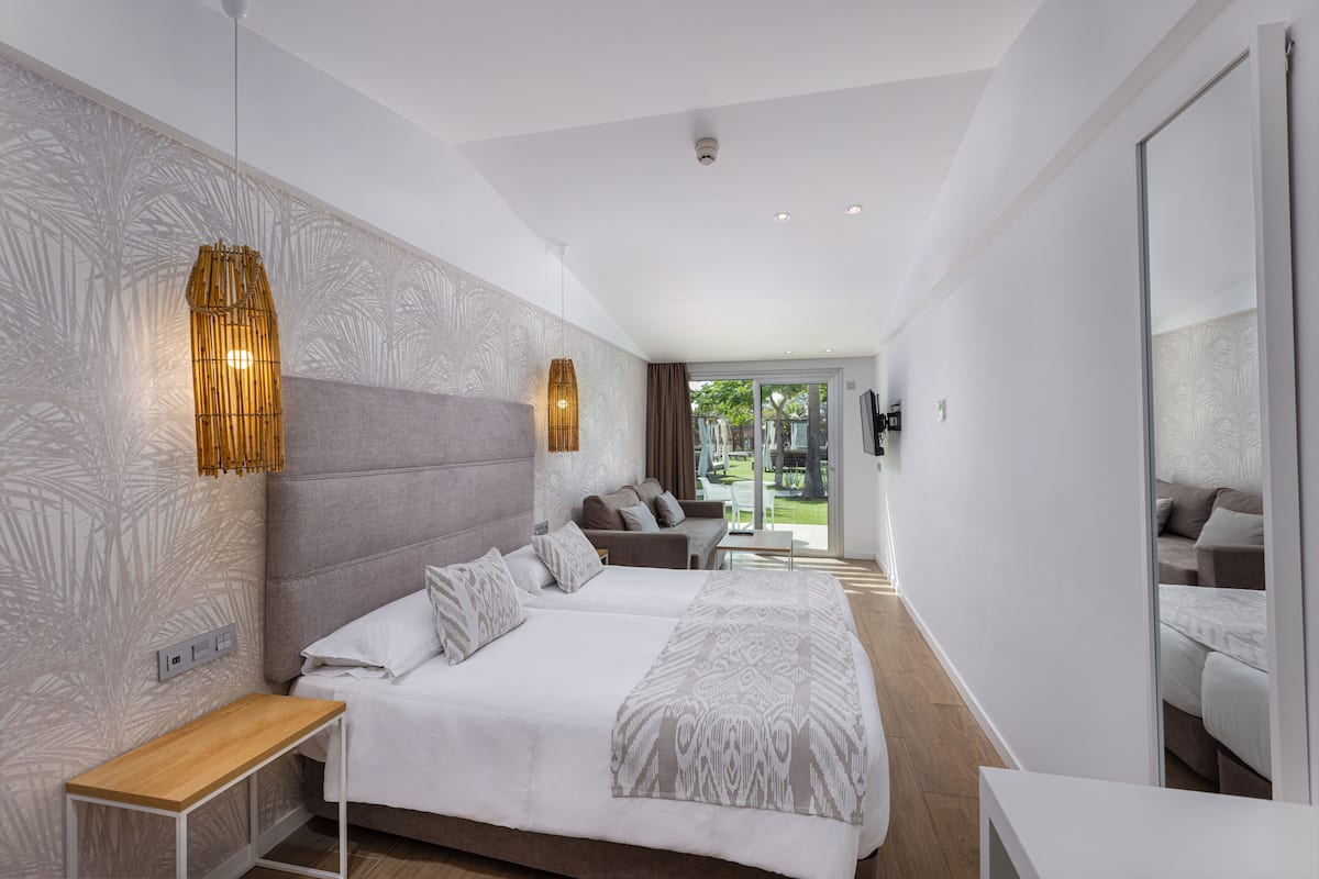 Une chambre d’hôtel moderne dotée d’un grand lit, d’un coin salon et offrant une vue sur l’extérieur.