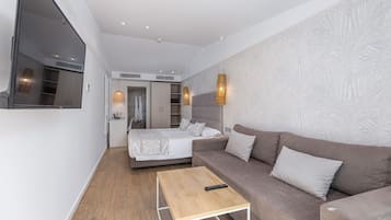 Ein modernes Hotelzimmer mit einem Bett, einer Couch, einem Holztisch und einem großen Spiegel.