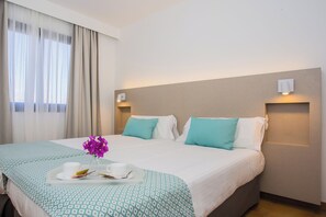 A hotel room with a bed, a tray with a cup and saucer, and a vase with flowers. - Los Tulipanes (Tias)
