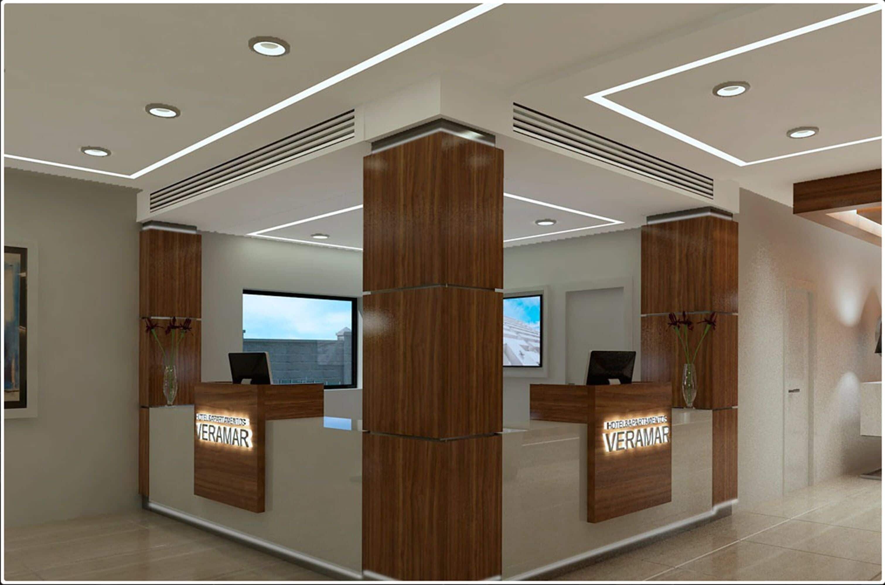 Zona de recepción de hotel con mostradores de madera, un televisor de pantalla plana grande y un diseño de techo moderno.