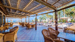 An outdoor seating area with wicker furniture and a view of the beach. - SBH Costa Calma Beach Resort (Pajara)