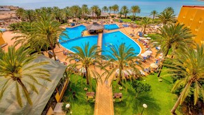 A resort with a central swimming pool, palm trees, and a beach view. - SBH Costa Calma Beach Resort (Pajara)