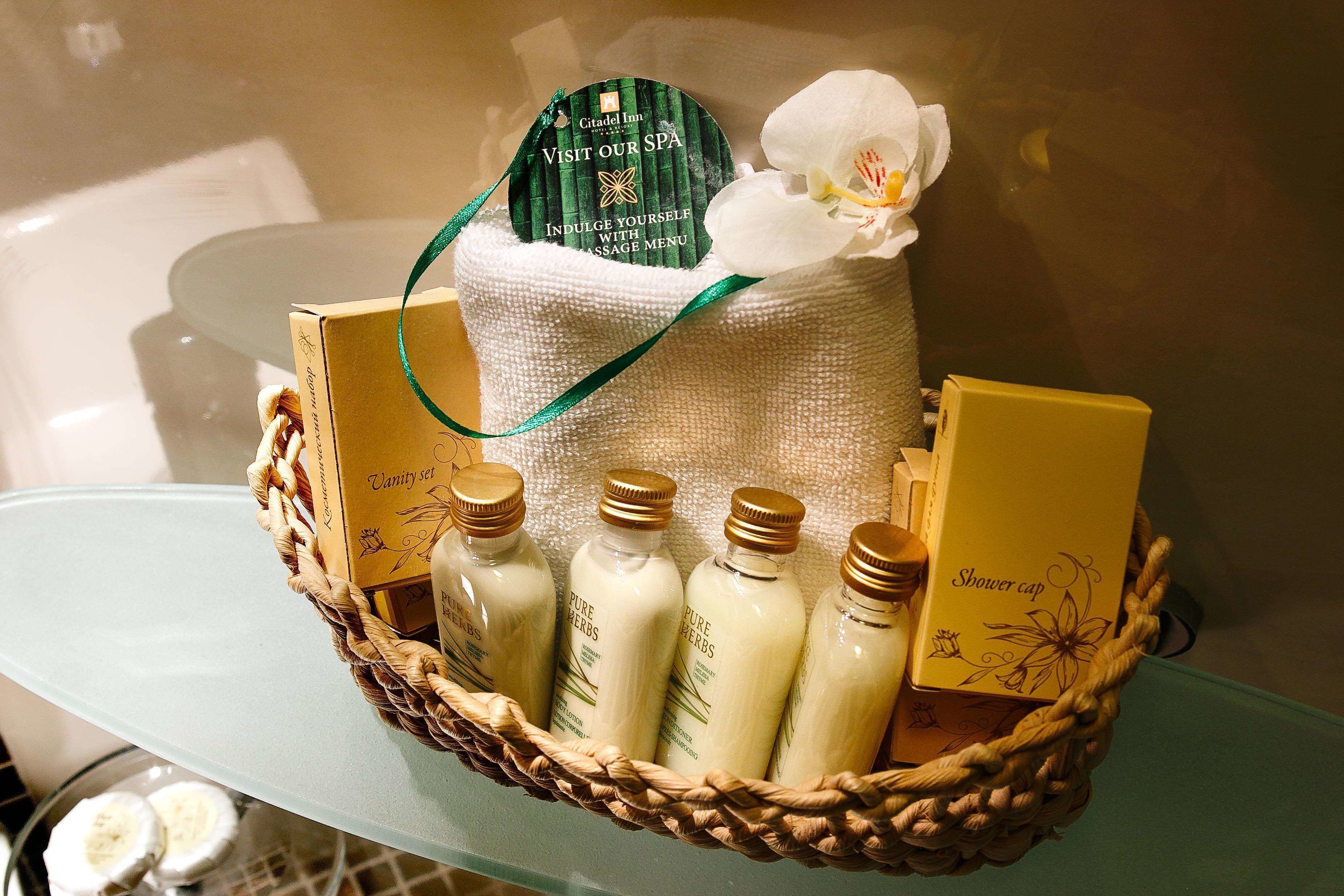A spa basket with various bath products and a spa invitation card.