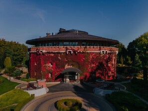 A building with a circular roof and brick walls covered in red foliage. - Citadel Inn Gastro Boutique Hotel (Lviv)