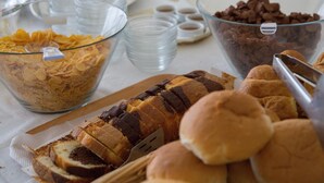 A buffet table with various food items including cereal, chocolate chips, and sliced bread. - International Hotel (Rhodes)