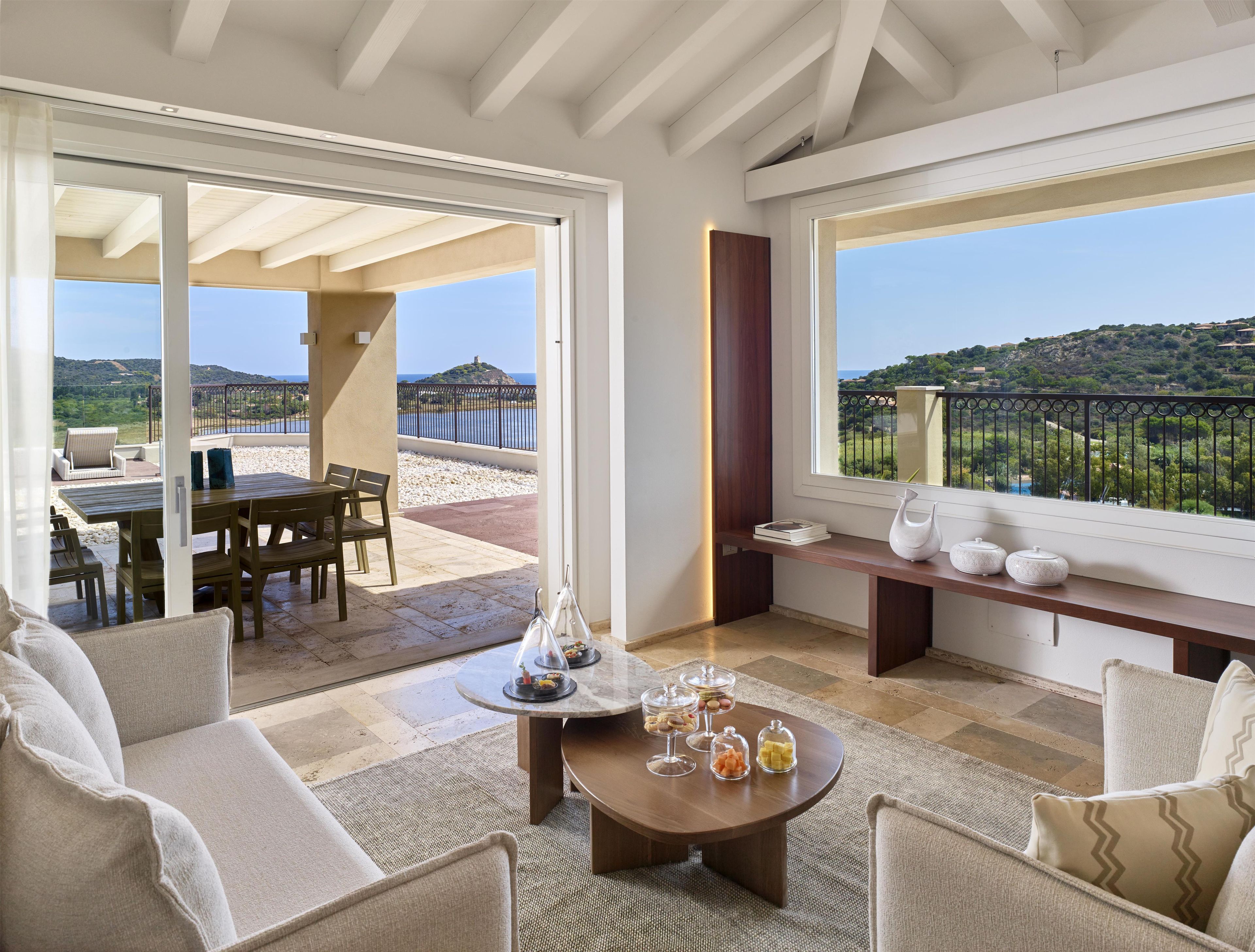 A spacious living area with a balcony, a dining set, and a coffee table with decorative items.