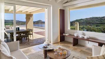 A spacious living area with a balcony, a dining set, and a coffee table with decorative items.