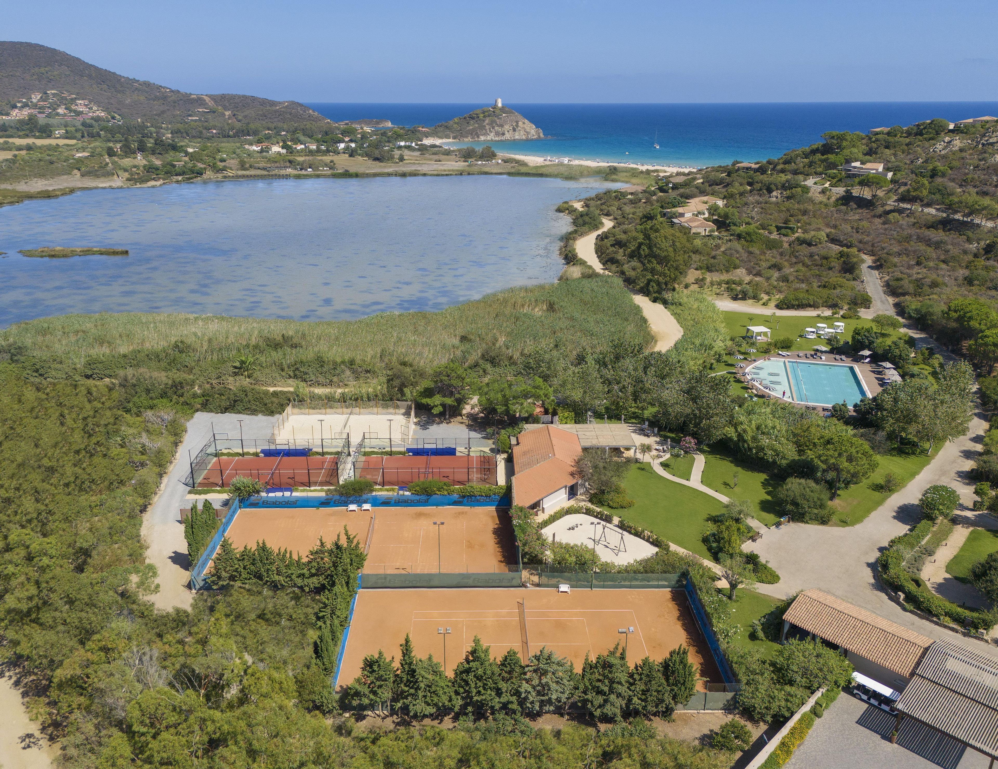 Una propiedad costera con cancha de tenis, piscina y vista al mar.