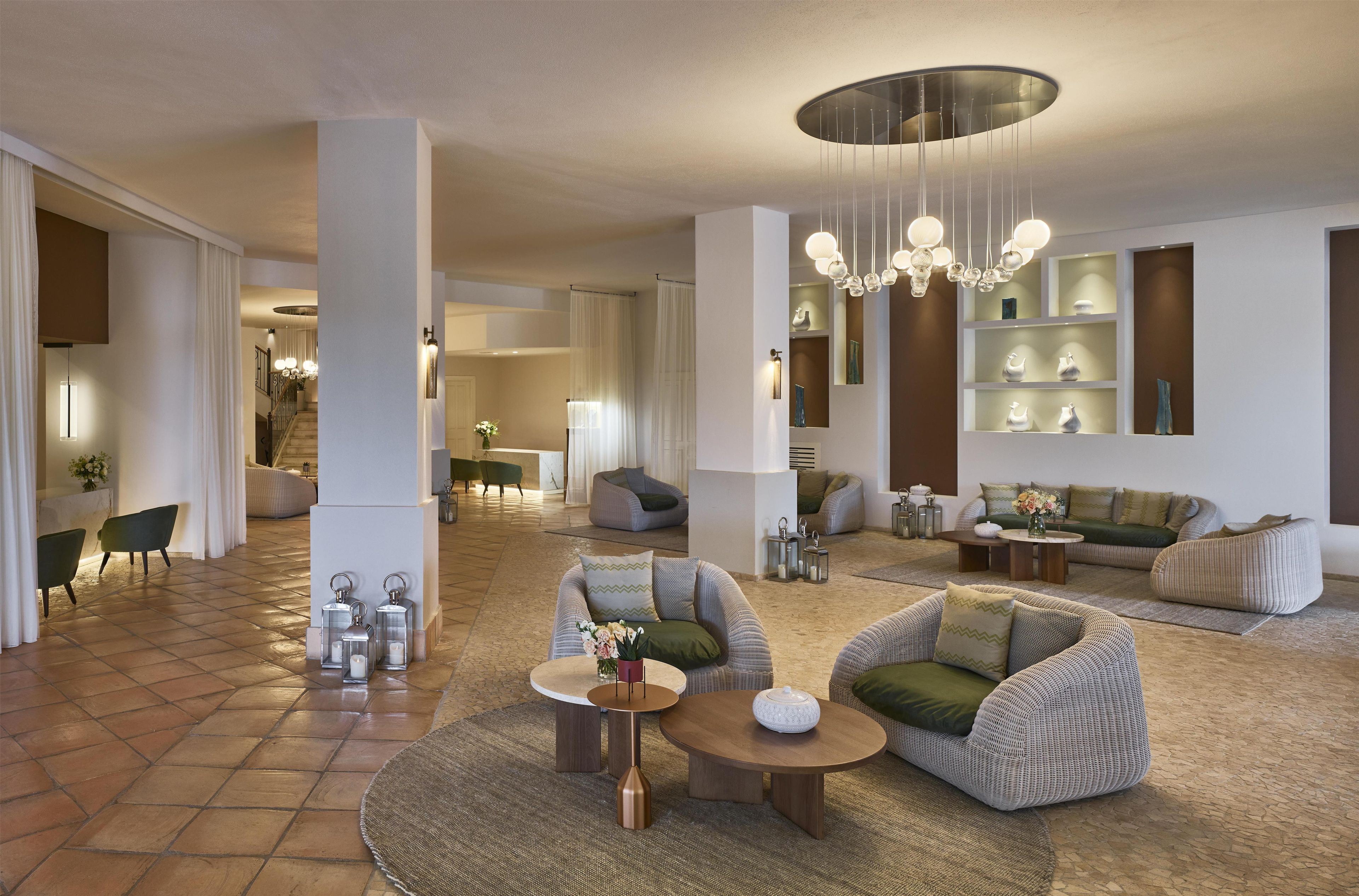 Un amplio salón con techo alto, muebles modernos y un candelabro central.