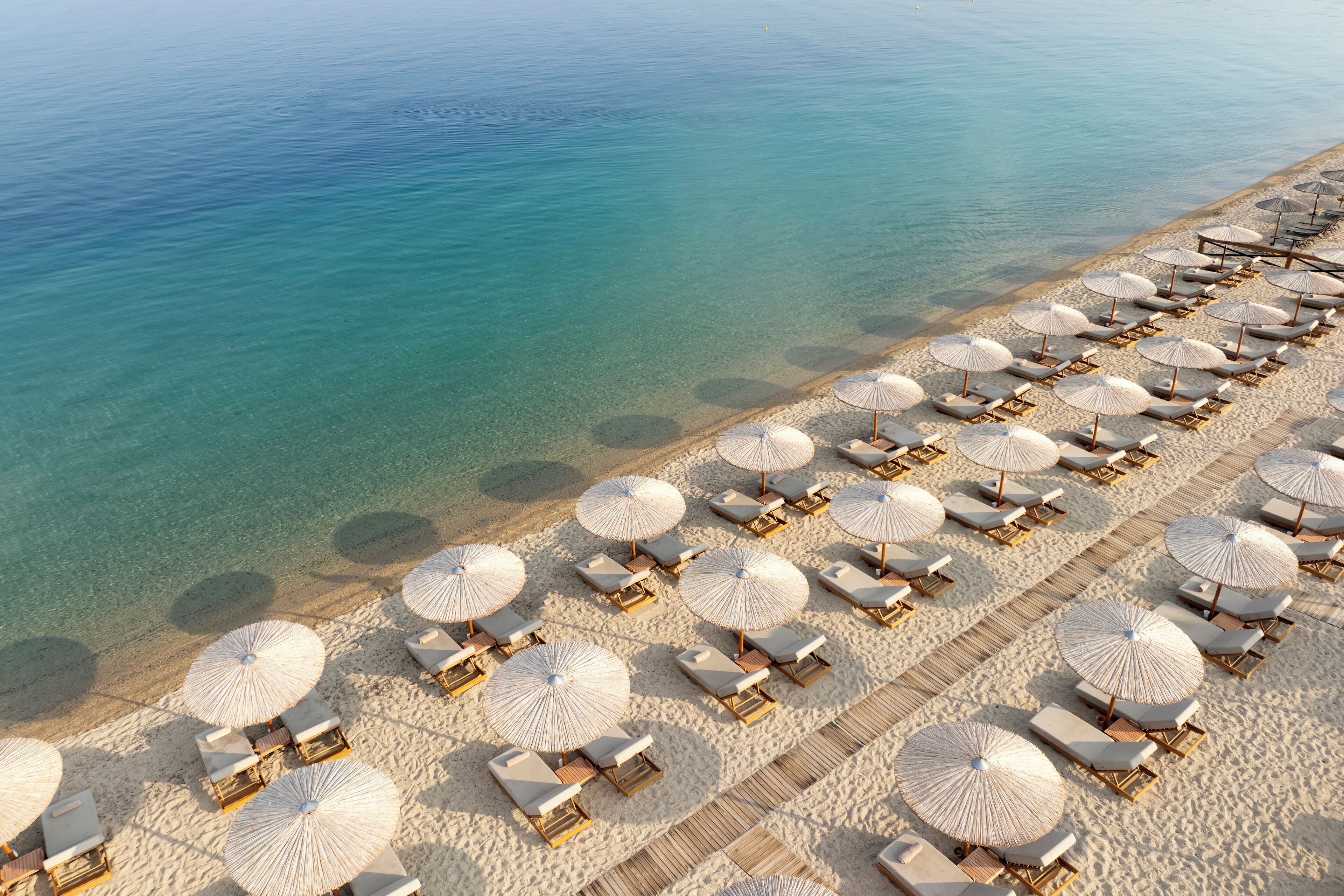 Plage, sable blanc, chaises longues, parasols