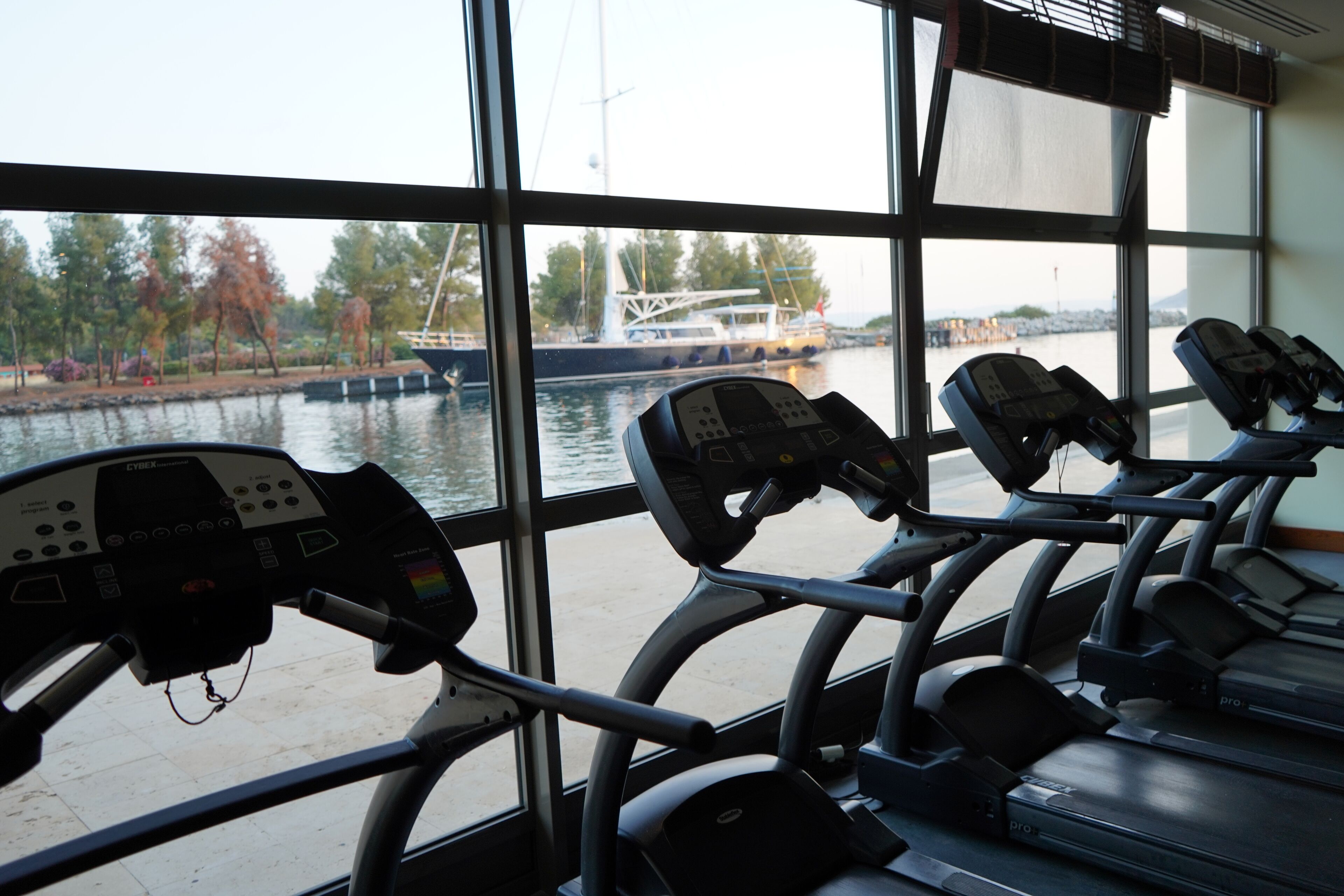 Ein Fitnessraum mit Ergometer und Blick auf einen Fluss.
