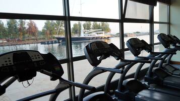 Ein Fitnessraum mit Ergometer und Blick auf einen Fluss.