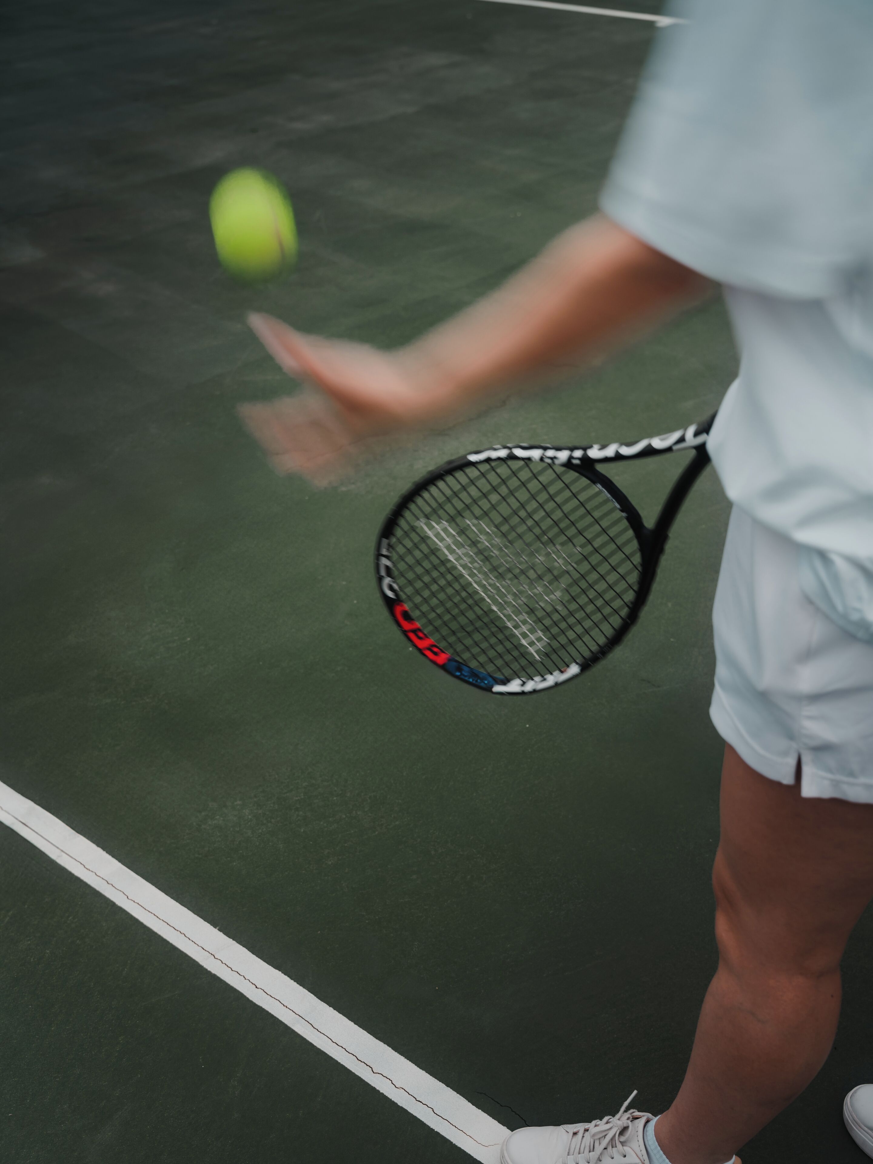 Una cancha de tenis con una red, una pelota y una raqueta.