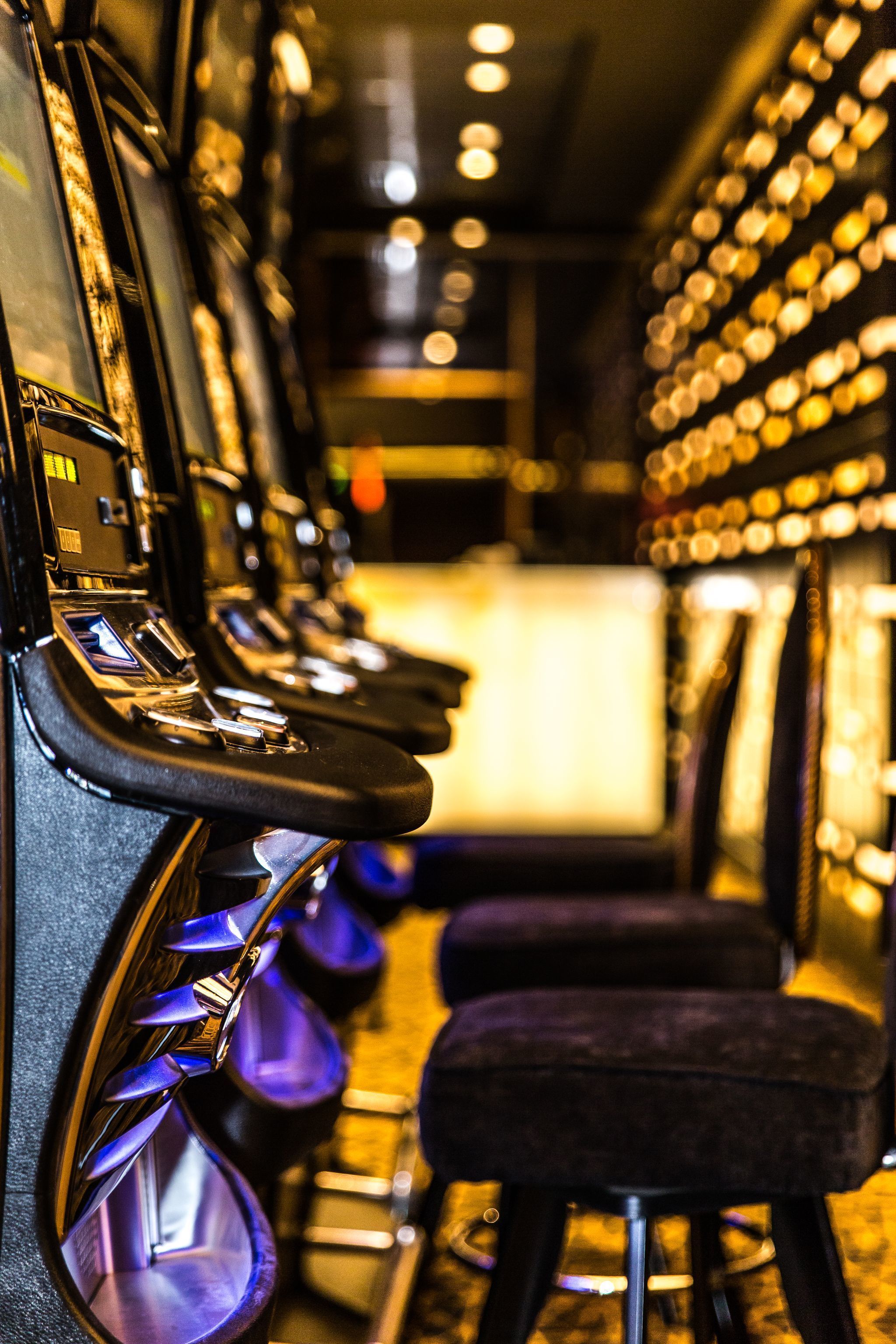 A row of slot machines with a bar area in the background.