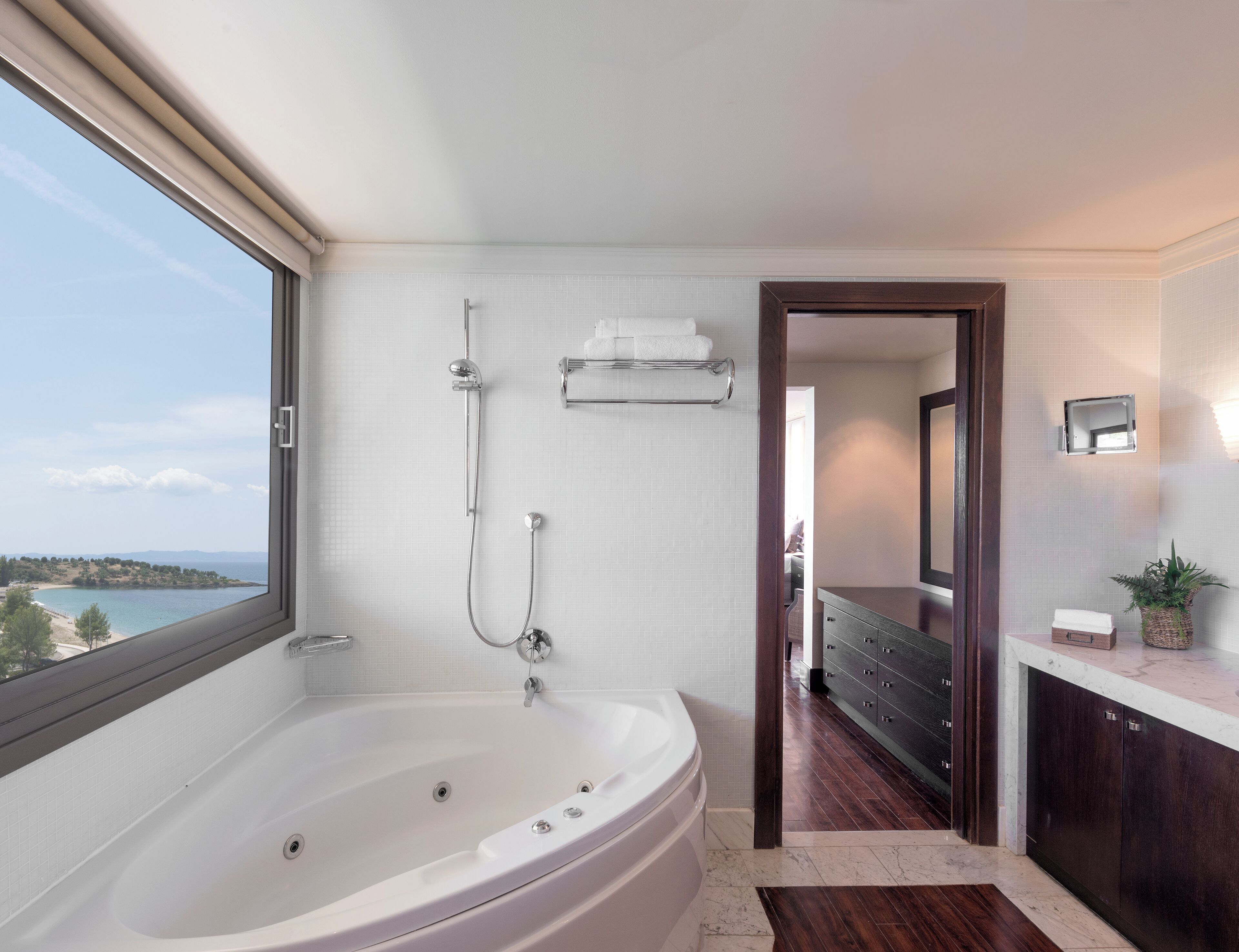 A modern bathroom with a large bathtub, a shower, and a vanity with a mirror.