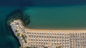 On the beach, white sand, sun-loungers, beach umbrellas