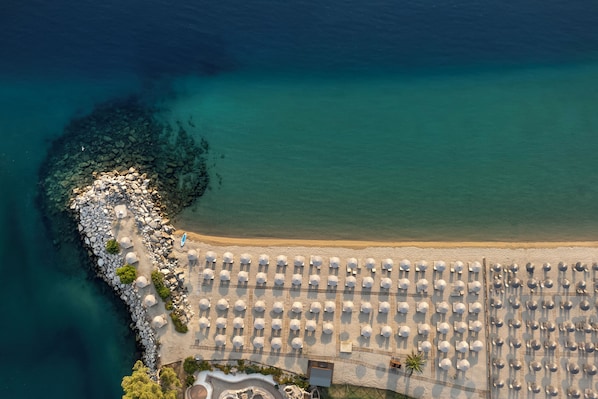 On the beach, white sand, sun loungers, beach umbrellas