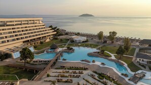 A resort with a large swimming pool, a bridge, and a view of the sea. - Porto Carras Meliton (Sithonia)