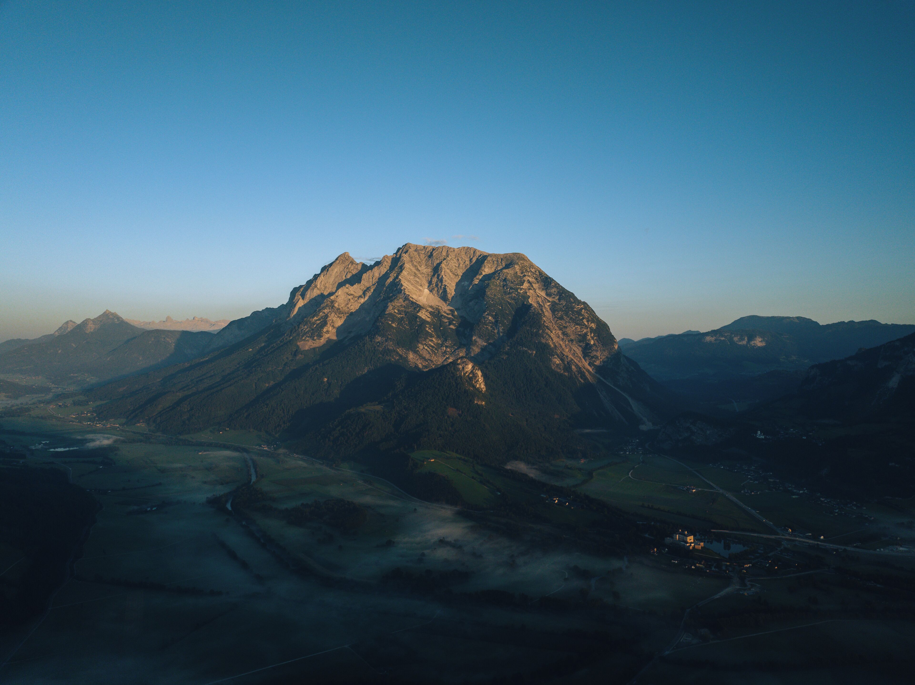 A mountain landscape with a prominent peak, valleys, and distant mountains.