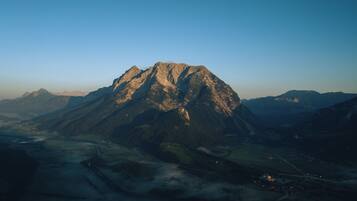 A mountain landscape with a prominent peak, valleys, and distant mountains.