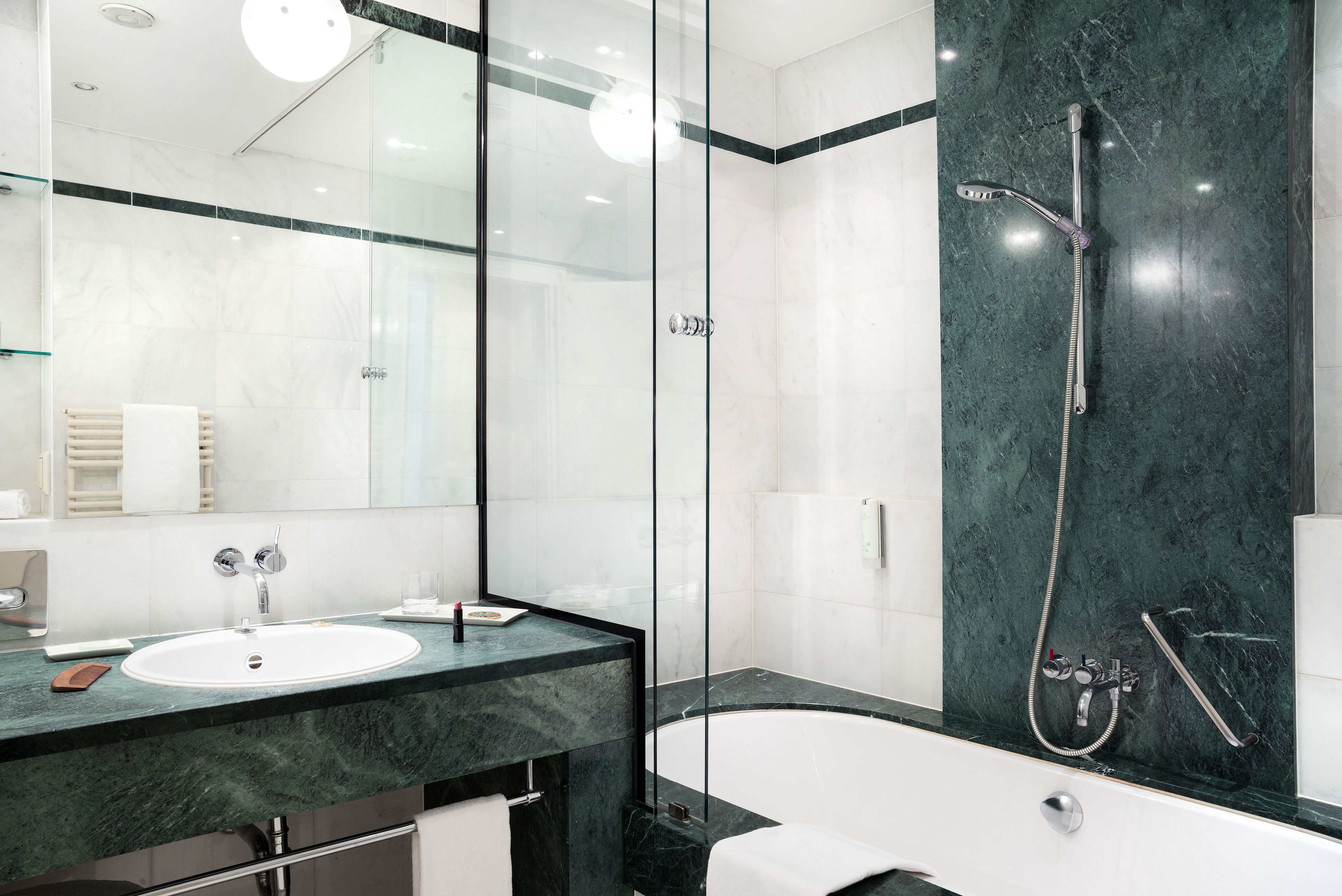 A modern bathroom with a glass-enclosed shower, a white sink, and a bathtub.