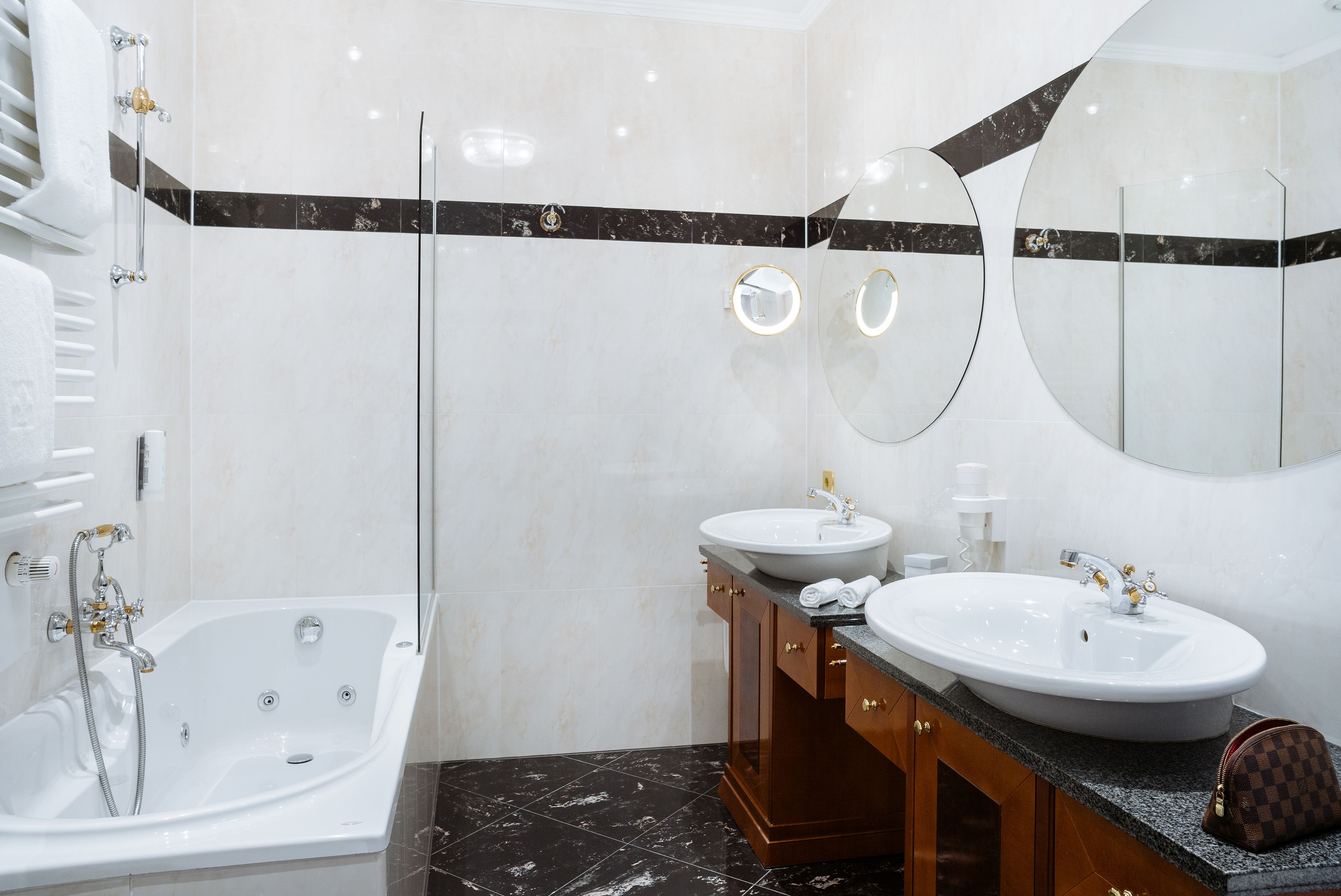 Une salle de bain moderne avec une baignoire, deux lavabos et un grand miroir.