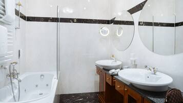 Une salle de bain moderne avec une baignoire, deux lavabos et un grand miroir.