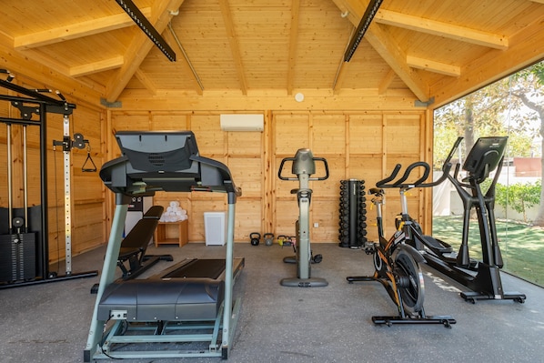 Una palestra con tapis roulant, macchinari ellittici e attrezzature per l'allenamento con i pesi.