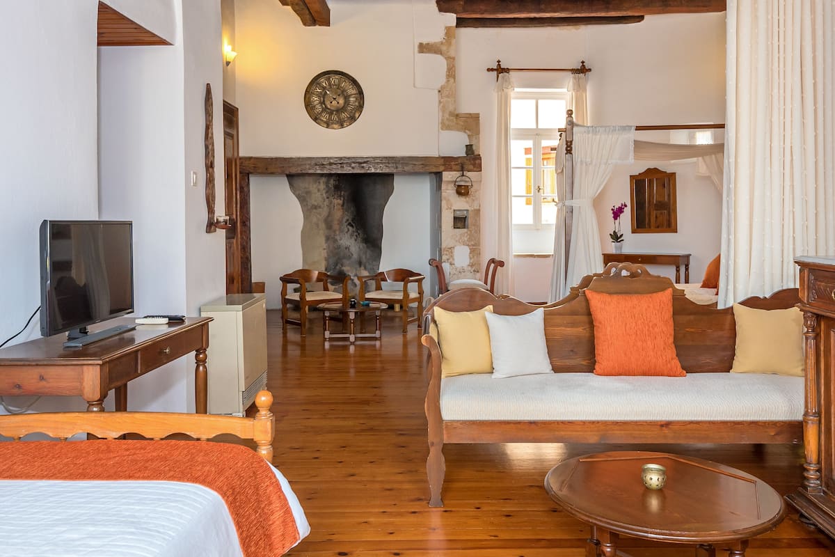 A cozy living room with a fireplace, wooden furniture, and a television.