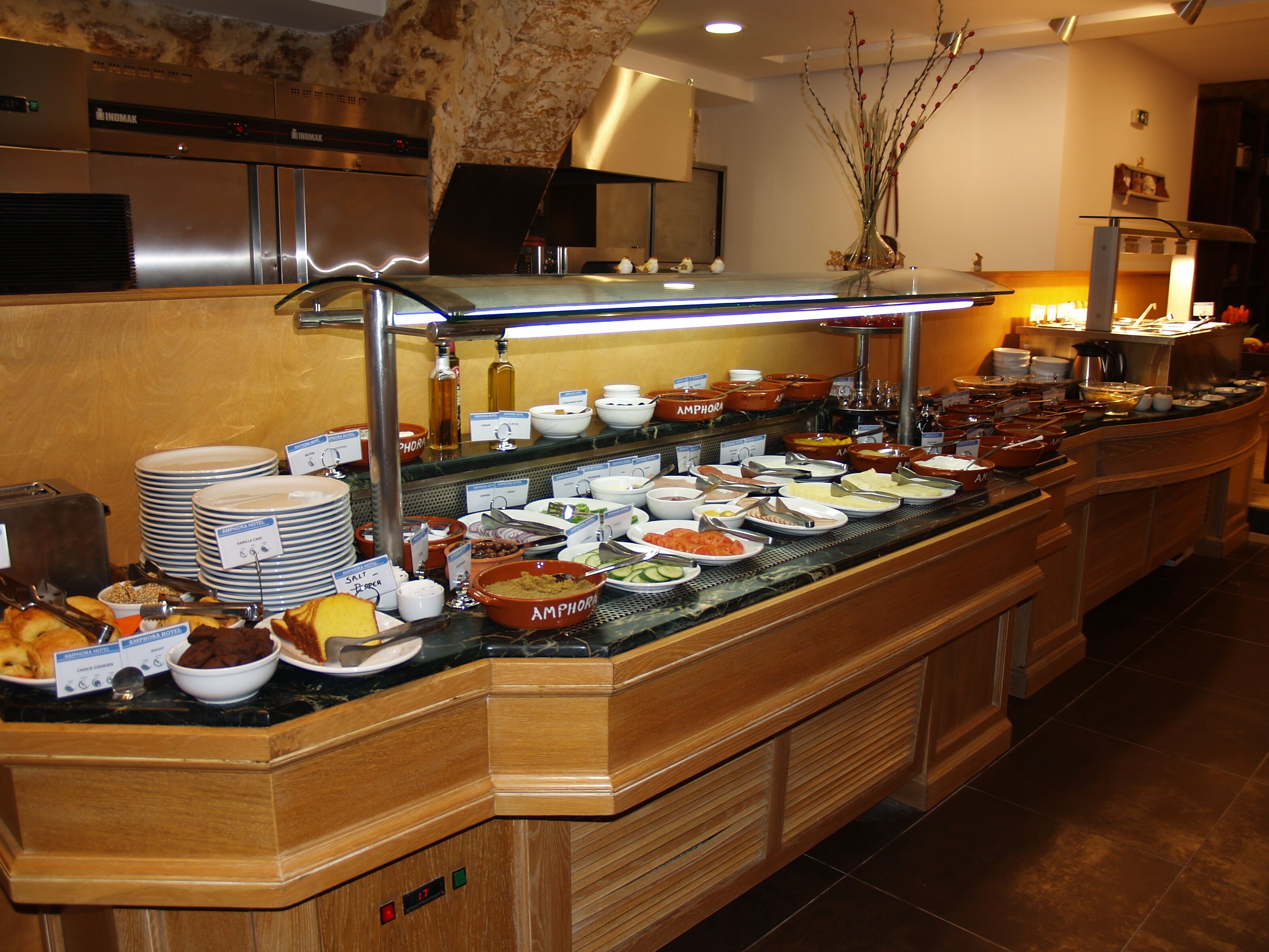 A buffet counter with various food items and condiments, a coffee machine, and a microwave.