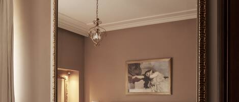 A room with a fireplace, a large mirror, and a painting on the wall.
