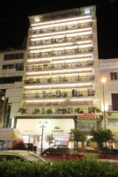 Un hotel de varios pisos con balcones, un letrero que dice 'Hotel Noufara' y locales comerciales adyacentes.