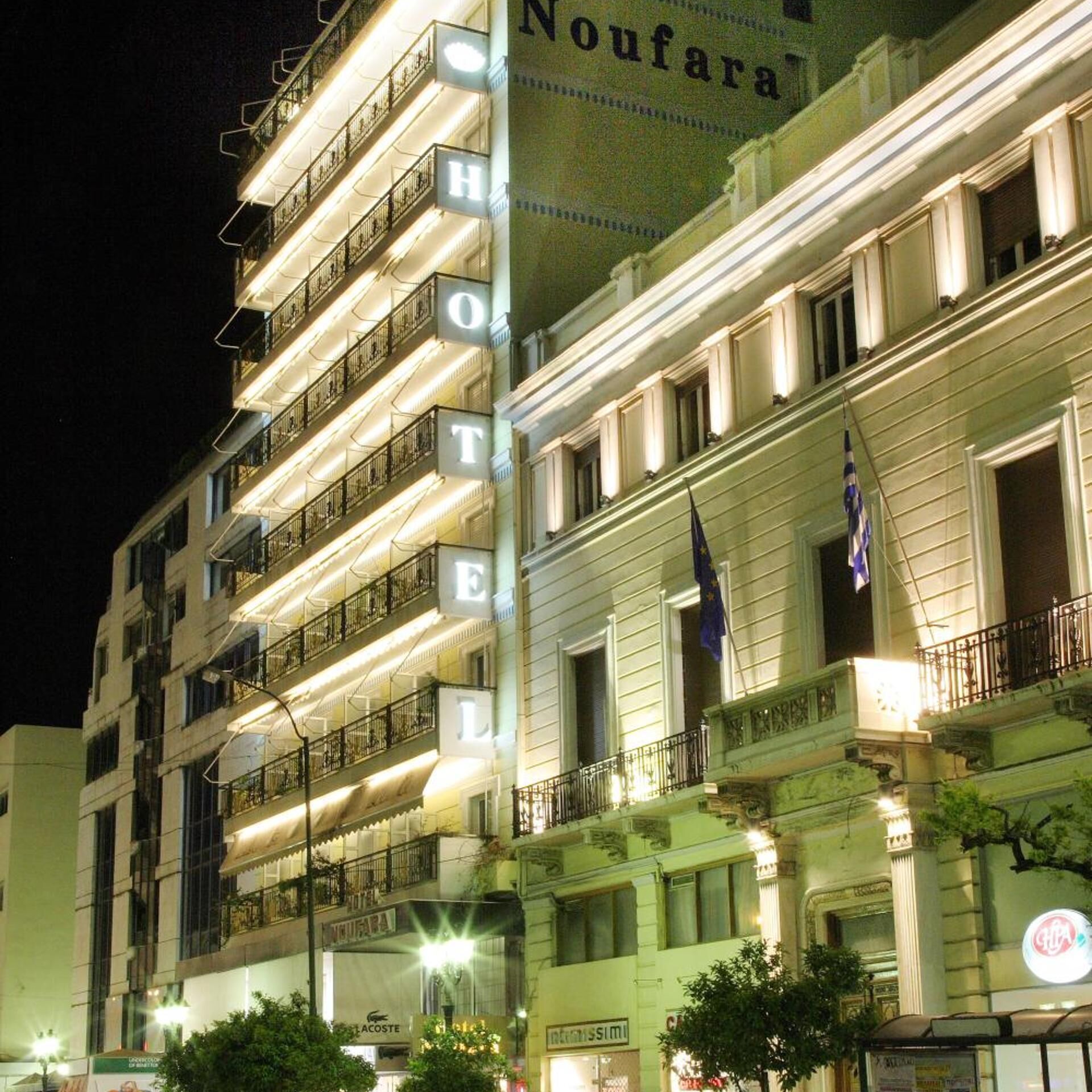 A multi-story hotel with illuminated balconies and a prominent sign.