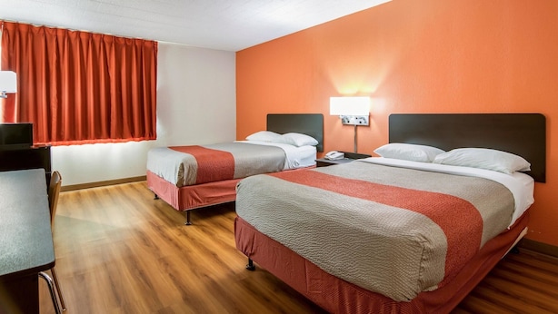 A hotel room with two beds, a desk, and a window with red curtains. - Motel 6 New Stanton, PA (New Stanton)