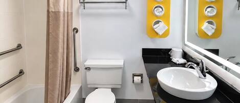 A modern bathroom with a bathtub, toilet, and sink.