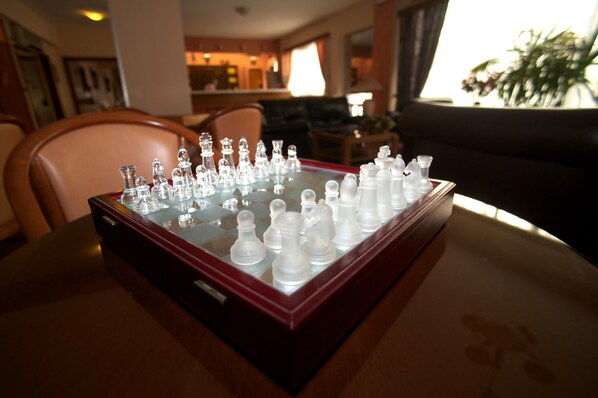 A chessboard on a table in a room with a couch and a window. - Anemoni (Piraeus)