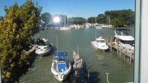 Un port de plaisance où sont amarrés plusieurs bateaux, entouré d’arbres et sous un ciel dégagé.