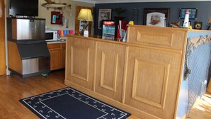Une cuisine avec des meubles de rangement en bois, un réfrigérateur, un four à micro-ondes et une machine à café.