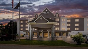 A hotel with a modern design, a covered entrance, and a sign indicating it is a Country Inn & Suites by Radisson.