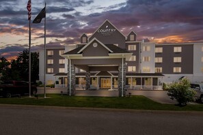 A hotel with a modern design, a covered entrance, and a sign indicating it is a Country Inn & Suites by Radisson.