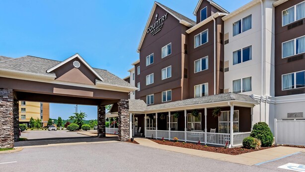 A Country Inn & Suites with a modern design, featuring a covered entrance and a patio area.