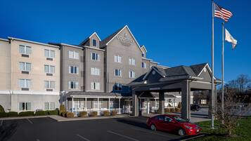 A multi-story hotel with a covered entrance and a parking lot.